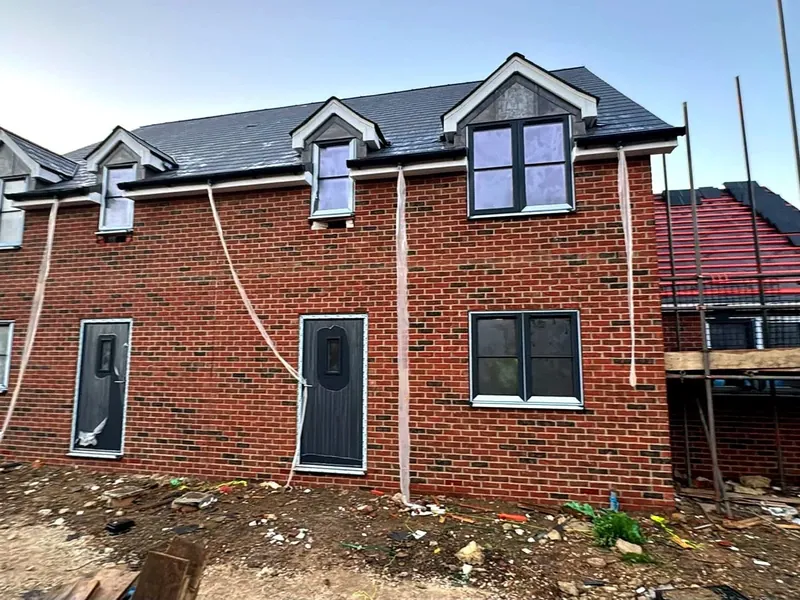 Red brick new build home with dormer windows by LS Brickwork Ltd