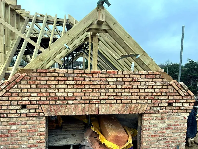 New build under construction with brick gable and roof trusses